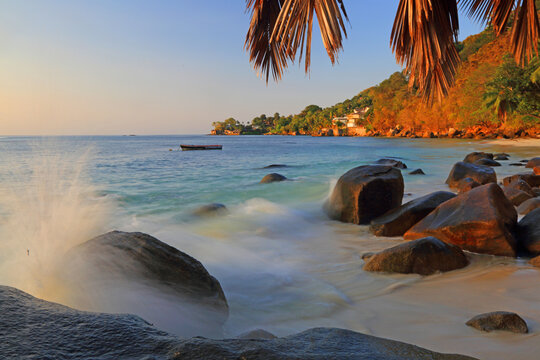Visitors enjoy the view and activities at Beau Vallon beach on Mahe in Seychelles during sunset hours