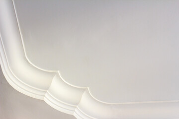 An elegant white interior ceiling featuring decorative curved crown molding with soft shadows and a clean, minimalist aesthetic © Lukman Riyadi