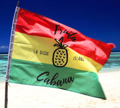 Fruta Cabana flag waving on Anse Source dArgent beach in Seychelles during sunny day