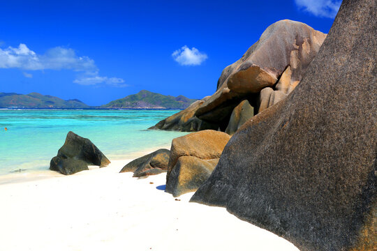 Beautiful beach scene at Anse Source d'Argent with clear water, rocks, and sand during a sunny day in Seychelles