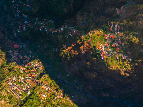Aerial view from Eira do Serrado shows valleys and mountains at sunset over Curral das Freiras in Madeira region, Portugal