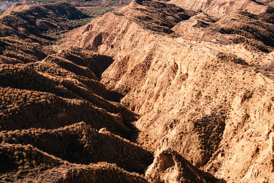 Eroded valleys and layered hills display the natural landscape in Desierto de Gorafe badlands of Granada, Andalusia, Spain