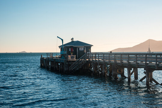 Wooden pier extending into water at sunset in Marlborough Sounds on South Island of New Zealand