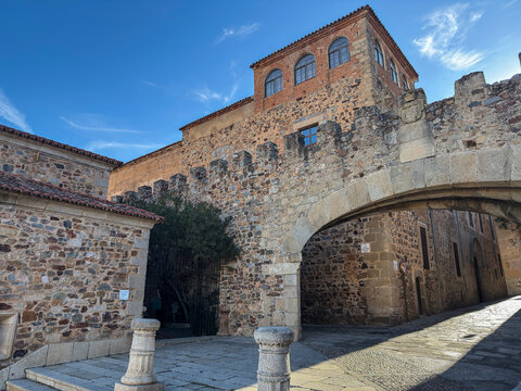 Exploring Arco de la Estrella in Plaza Major in Caceres, visitors admire the historic arch and its surroundings in Spain