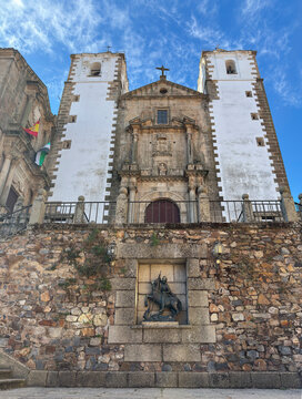 Statue of St George with Church of San Francisco Javier in Caceres, Spain, under clear sky