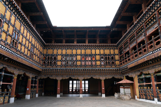 Visitors admire the architecture and details of Rinpong Dzong Monastery in Paro, Bhutan during daytime hours
