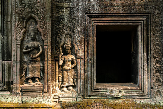 Intricate carvings on walls of Ta Prohm Temple showcase ancient artistry in Cambodia's historical site near Siem Reap