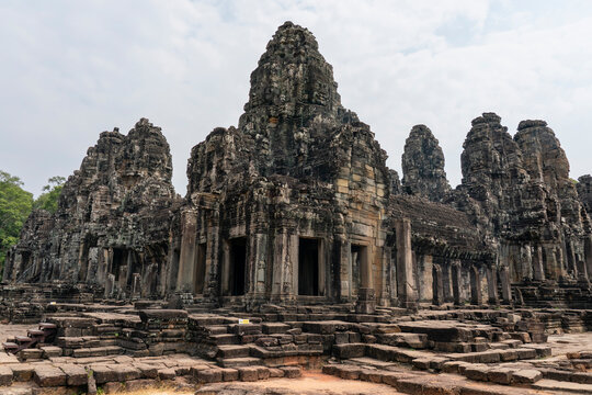 Exploring the architecture of Bayon Temple with stone towers and ruins in Angkor, Cambodia near Siem Reap