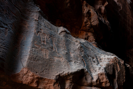 Ancient stone-age petroglyphs carved into rock formations in Khazali Canyon of Wadi Rum desert in Jordan