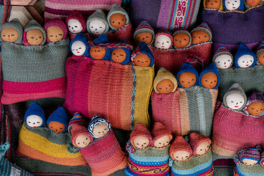 Colorful textiles and handcrafted dolls displayed at traditional center in Chinchero, Peru creating a vibrant cultural showcase