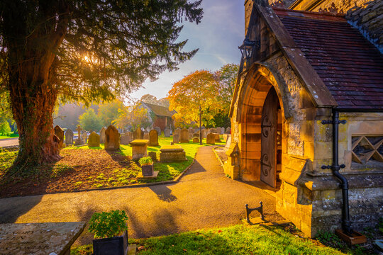 View of Parish Church in Ashford surrounded by water and autumn colors in Derbyshire, England