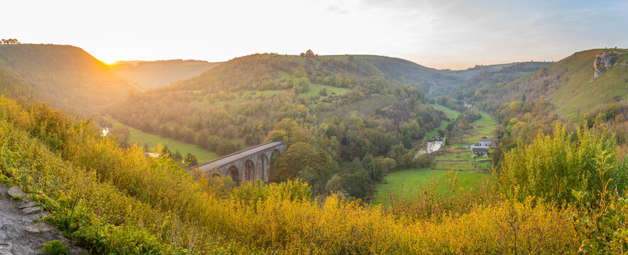 View of Monsal Dale and a stone viaduct at sunset with autumn colors in Derbyshire Dales, UK
