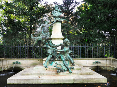 Sculpture of the Delacroix Monument in the Jardin du Luxembourg with figures surrounded by greenery in Paris