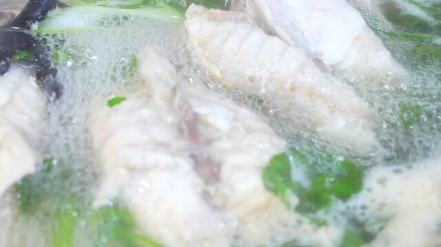 Clear pufferfish soup boiling with vegetables