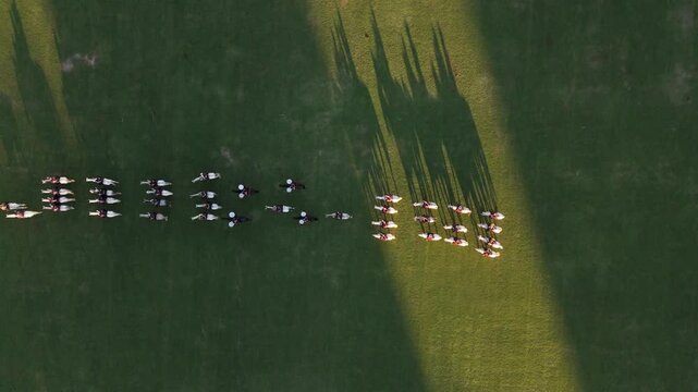 Cavalry troops on horseback form lines on grassy field at Campo Argentino de Polo
