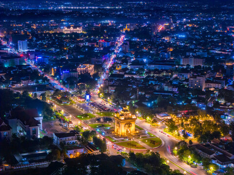 Stunning aerial night view of Patuxai Victory Monument and the illuminated cityscape of Vientiane, Laos.