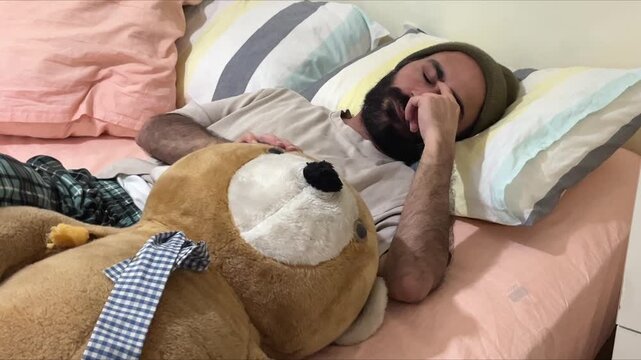 Adult Male Patient Clutches Giant Teddy Bear in Bed, Symbolizing Loneliness, Depression, Anxiety and Mental Health Isolation