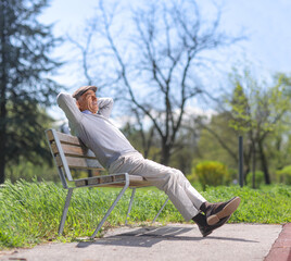 Fototapeta premium Elderly man relaxing on a park bench
