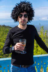 Obraz premium Georgian man in a papakhi with a glass of wine. Selective focus.