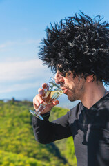 Obraz premium Georgian man in a papakhi with a glass of wine. Selective focus.