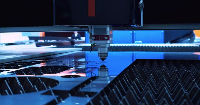 Modern industrial equipment processes a metal part with high precision using a laser beam. Close-up.
