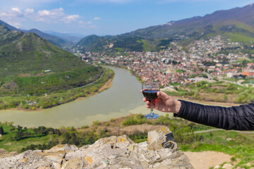 Obraz premium Georgian man in a papakhi with a glass of wine. Selective focus.