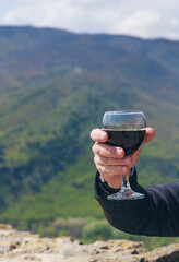 Obraz premium Georgian man in a papakhi with a glass of wine. Selective focus.