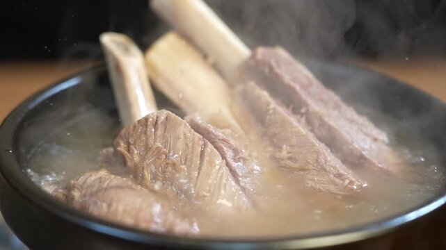 Galbitang served in earthenware pot with broth poured over it