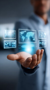 Businessman holding futuristic digital interface with holographic world map and data analytics screens. Innovative technology concept for global business solutions and virtual communication tools