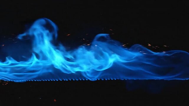 A vibrant display of blue flames dancing against a dark, mysterious background