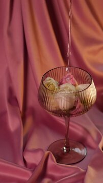Water pouring into a glass filled with fresh eustoma flowers