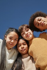 Fototapeta premium Group of children smiling and looking down at camera outdoors