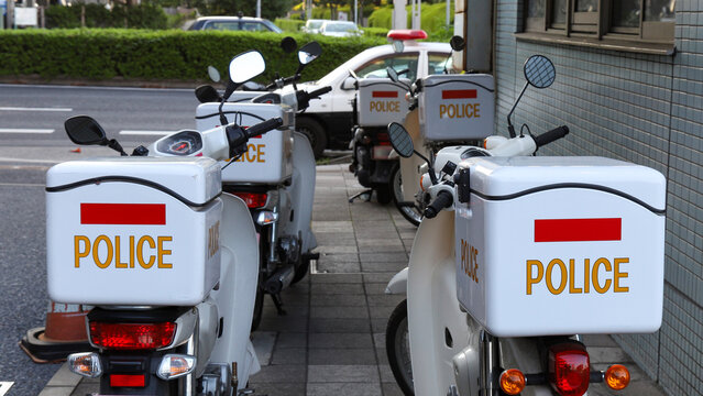 駐輪場に並んで停車している日本の警察のミニパトロールバイク
