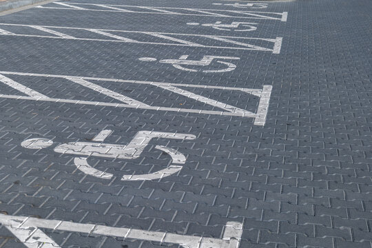 Parking spaces are marked clearly for people with disabilities in a busy parking lot