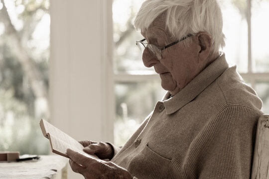 elderly man at home , reading a book