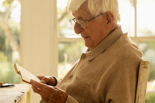 elderly man at home , reading a book