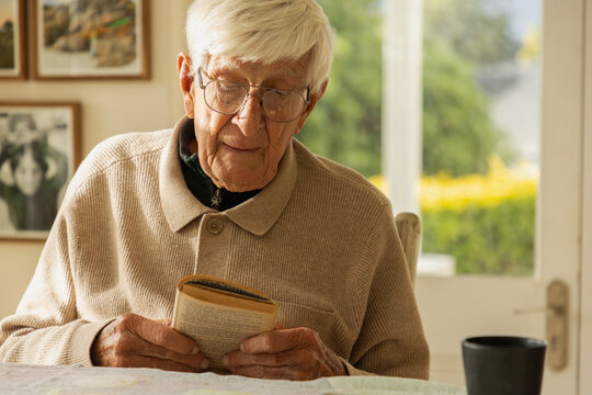 elderly man at home , reading a book