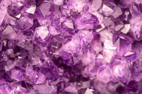 Amethyst purple crystals. Gems. Mineral crystals in the natural environment. Texture of precious and semiprecious stones. Seamless background with copy space colored shiny surface of precious stones.
