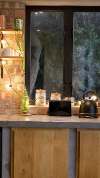 Vertical video: Starting camera pan revealing kitchen counter, showcasing black toaster and kettle