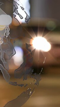 Vertical video: Bright flare sparking clear globe overlay, turning, revealing coasts, showing reach