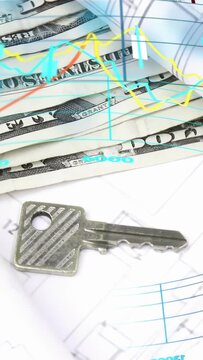 Vertical video: Cam panning revealing money and key as charts sliding across plans showing funding