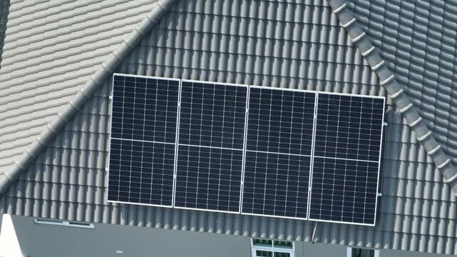 Aerial view of solar panels installed on a residential rooftop, highlighting clean renewable energy adoption, energy efficiency, reduced electricity costs, sustainable living benefits for the future.
