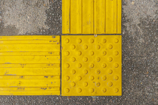 Yellow and grey floor tiles on the street. Floor tiles pattern.
