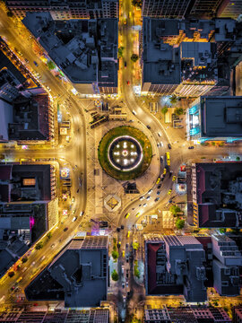Aerial overhead view of the illuminated Omonia Square in central Athens, Greece, with street traffic