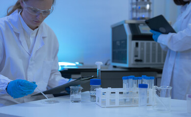 Naklejka premium Lab work, scientists holds a test tube takes the test from a test tube in analysis for vaccine development.