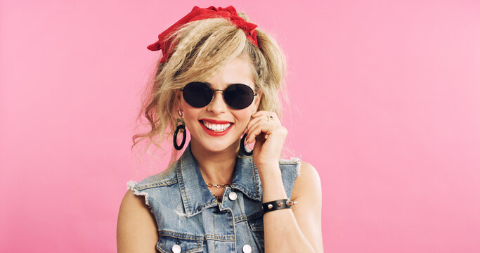Fashion, retro and woman in studio with sunglasses, pop clothing or classic outfit in 80s aesthetic. Vintage, space and person with eyewear, nostalgic apparel or rock style on pink background.