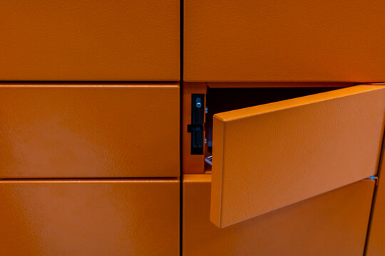 Orange parcel locker with open compartment, close up automated delivery detail. Concept: online shopping