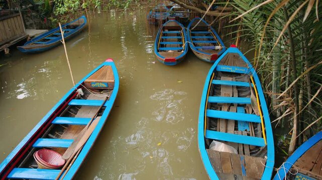 Traditional wooden boats floating on muddy river in mekong delta, vietnam for tourist river tours