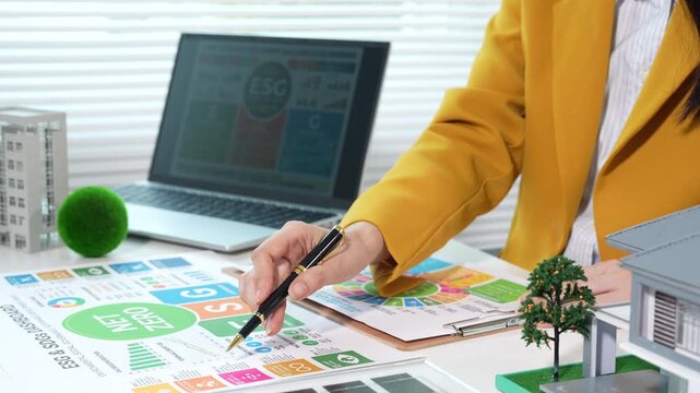 Businesswoman presenting eco-friendly concepts with net zero ESG reports, renewable energy models, and sustainable business planning in a modern office environment.