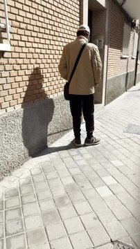 Ciego invidente con bast&oacute;n blanco tintineo palo telesc&oacute;pico roce, contera y punta plegable en suelo blind caminando dando palos de ciego en acera calle rolling tip